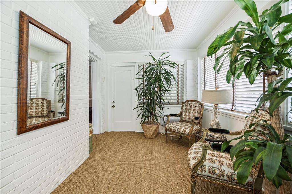 Bright and welcoming office/sunroom with charming beadboard ceiling and natural woven flooring.