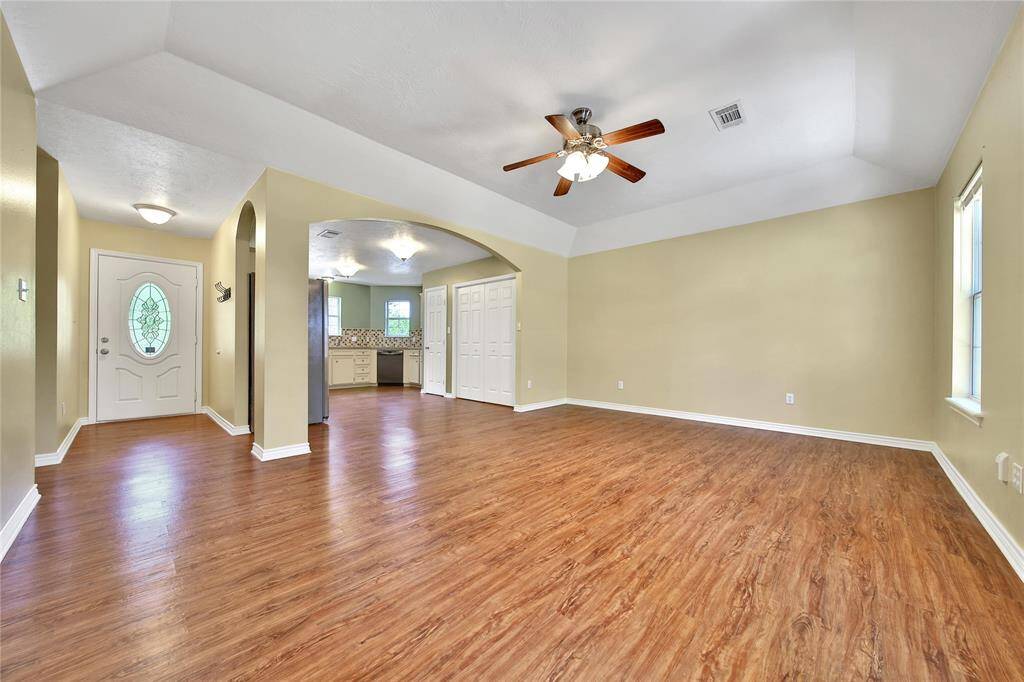 View from backdoor, the entryway opens to the living and kitchen seamlessly. Single door in kitchen is walk in pantry and double doors open to laundry.