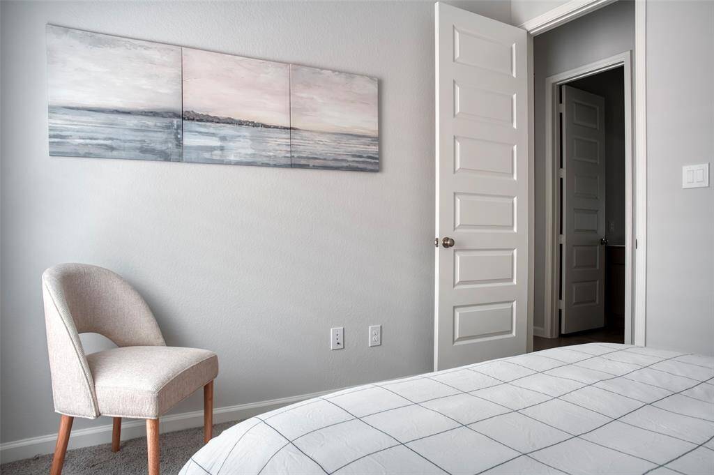 Discover a tranquil bedroom retreat featuring modern decor, soft neutral tones, and a stylish chair. Perfect for relaxation and comfort.