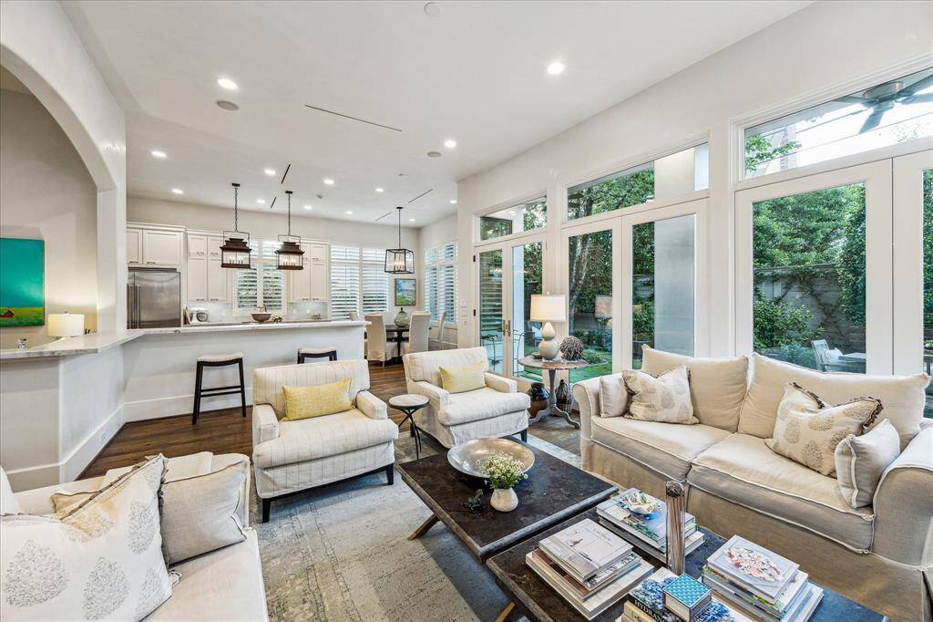 Open-concept flow from kitchen to living and breakfast areas, all framed by natural light and courtyard views.