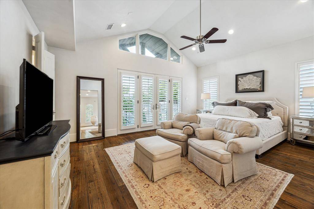 Primary suite with vaulted ceiling, French doors to private balcony, and abundant natural light.