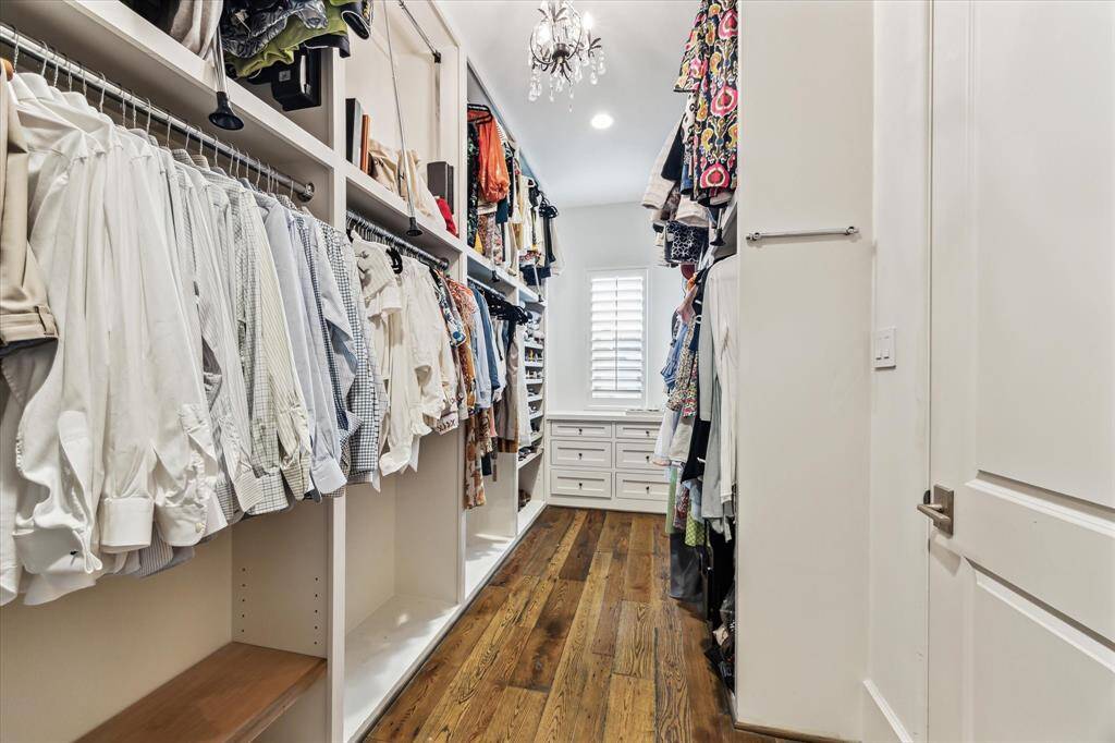 Spacious primary closet with built-ins, abundant hanging space, and natural light.