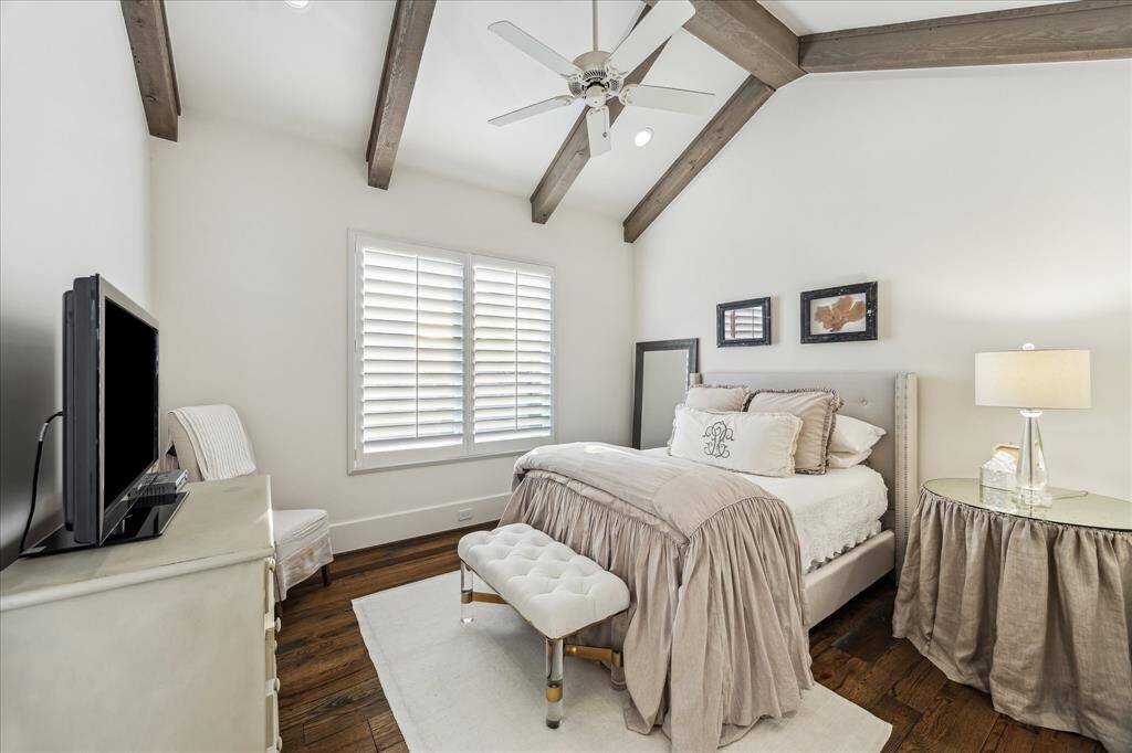 Secondary bedroom with vaulted ceiling, wood beams, and natural light—ideal as a guest suite or upstairs retreat.