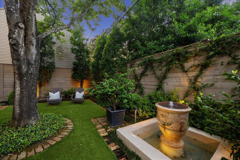 Lush garden retreat with turf yard, mature trees, and a tranquil fountain—perfect for quiet mornings or evening gatherings.