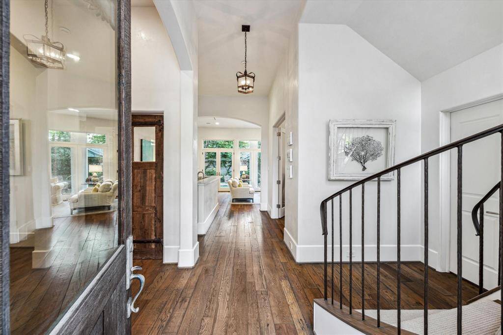 Inviting entry with Venetian plaster walls, reclaimed barnwood floors, and arched hallway leading to sunlit living spaces—sets the tone for refined elegance throughout.