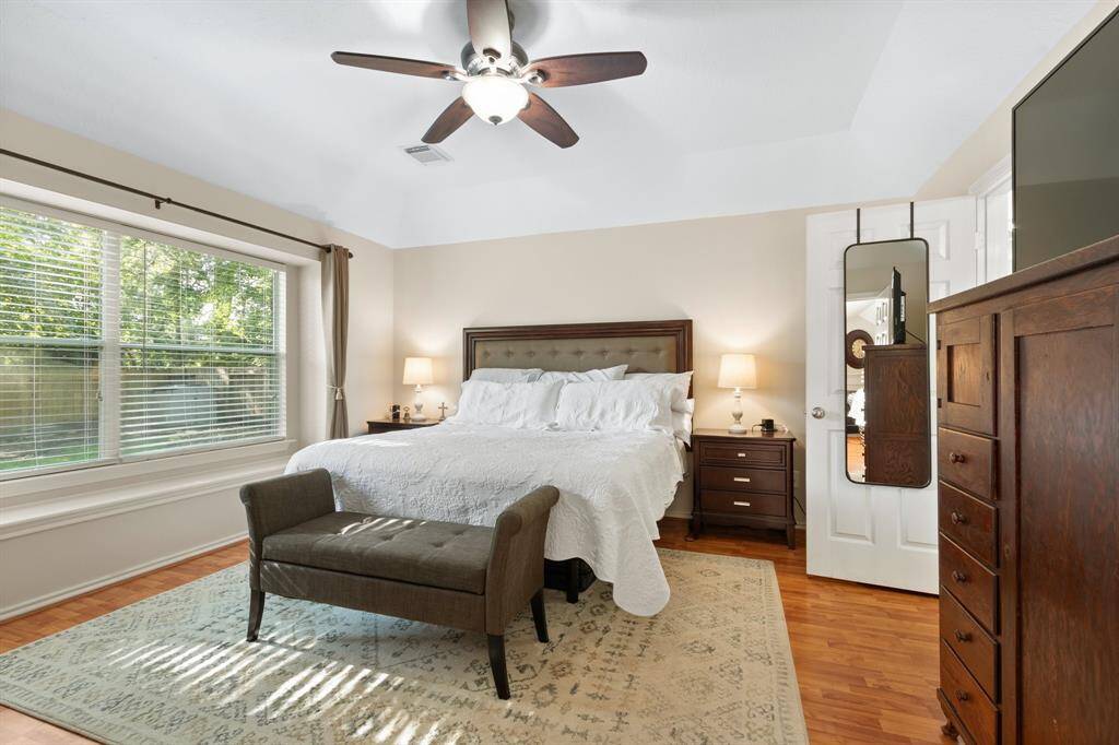 This is a well-lit secondary upstairs bedroom. Added to the rooms character is a coffered ceiling, arched window opening and a walk-in closet.