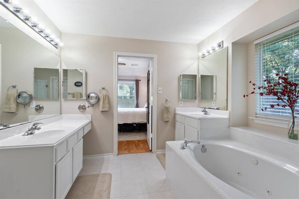 The upstairs bathroom is equipped with dual vanity sinks, an upper cabinet for storage, a convenient tub/shower combination, and easy-to-maintain tile floors.