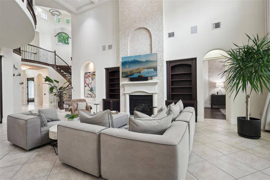 Large windows and an elegant staircase enhance the open, airy feel, while the neutral palette adds a touch of sophistication.