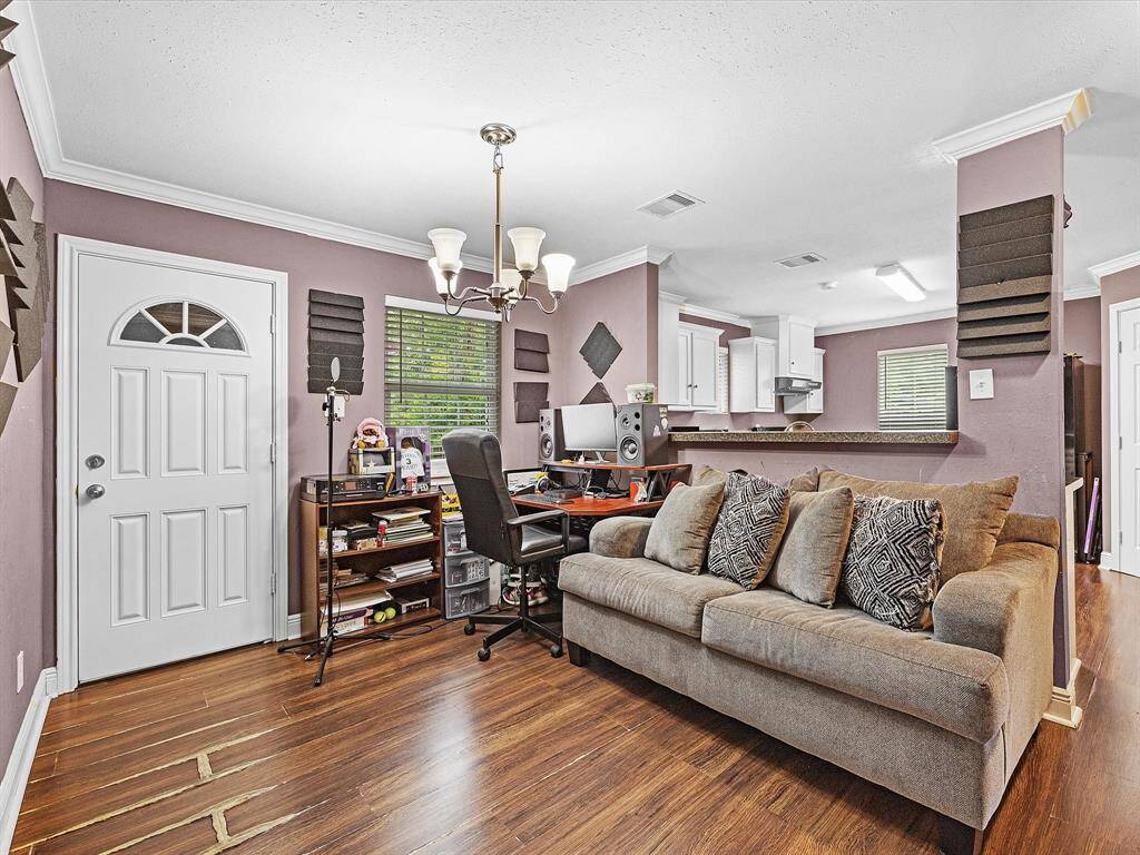 There’s a dedicated space that can serve as a dining area, home office, or flex room, offering plenty of versatility to suit your needs. A nearby door leads to a convenient laundry area and a small storage room, adding functionality and ease to daily living.