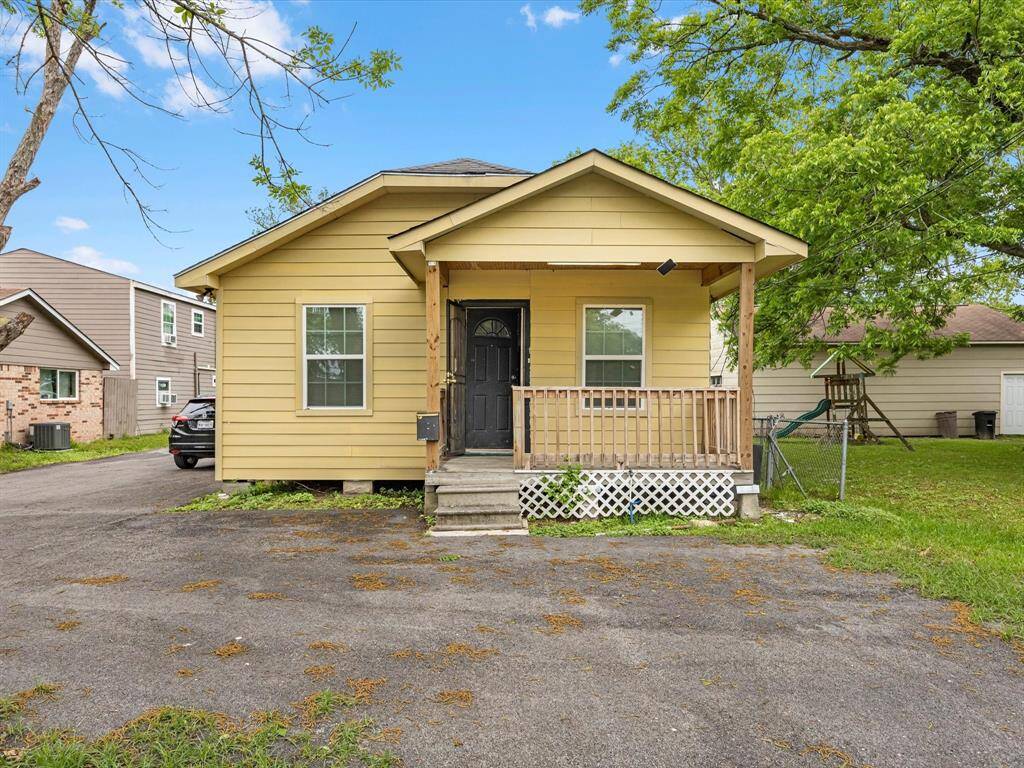 Unit #1 single-story house with a small front porch, features a paved driveway and a spacious yard.