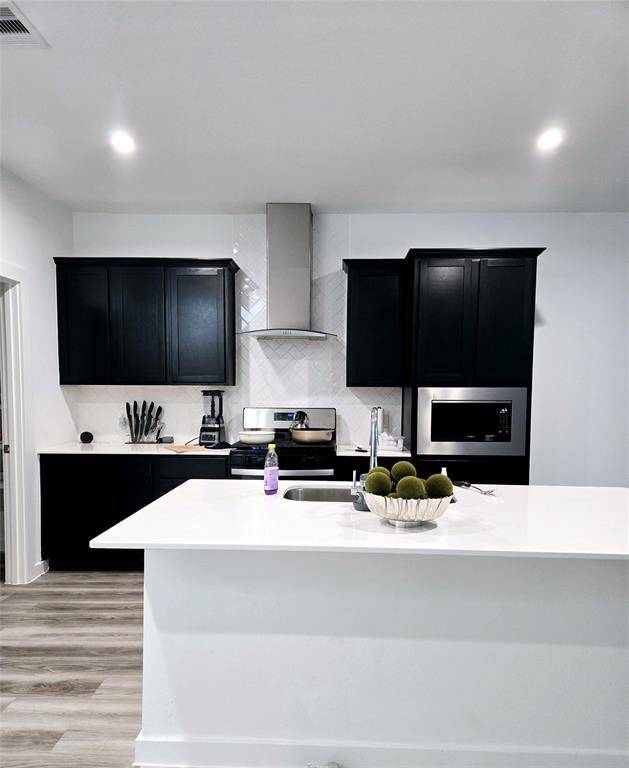 Modern smart home featuring an open kitchen with sleek stainless steel appliances.