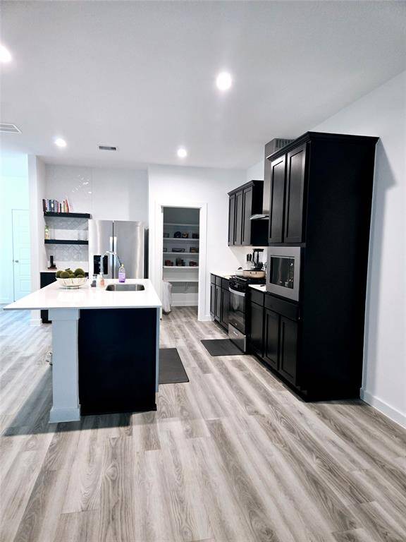 Discover abundant storage with a well-equipped butler's pantry, featuring a refrigerator, washer-dryer, and smart hub.