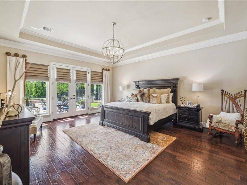 The expansive Primary Suite has private doors out to a private patio area. Look at all the room for furniture, sitting areas and King sized bed. The tray ceilings, crown molding and custom window coverings make for a unique Primary retreat.