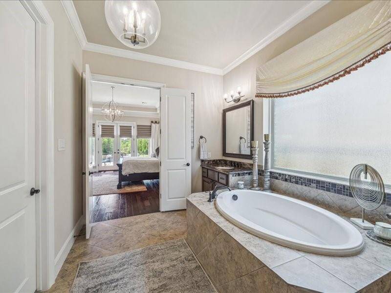 Look at this beautiful soaking tub in the Spa like bath.  Double doors, his/ her vanity areas make for the perfect setting.