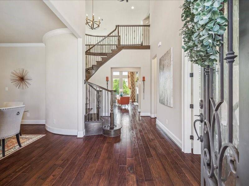 The 2 story entry is flanked by a expansive dining area and a private office with French Doors. Look at the beautiful wrought iron stairway.