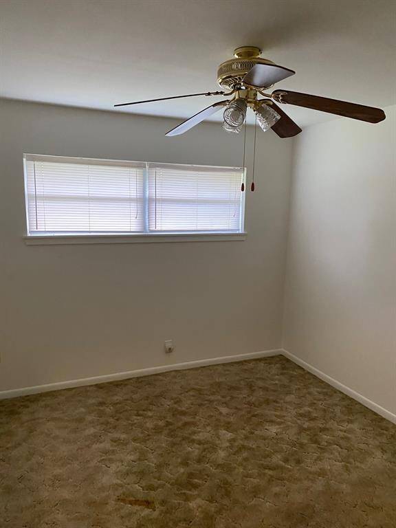 large den with fireplace looking out into back yard