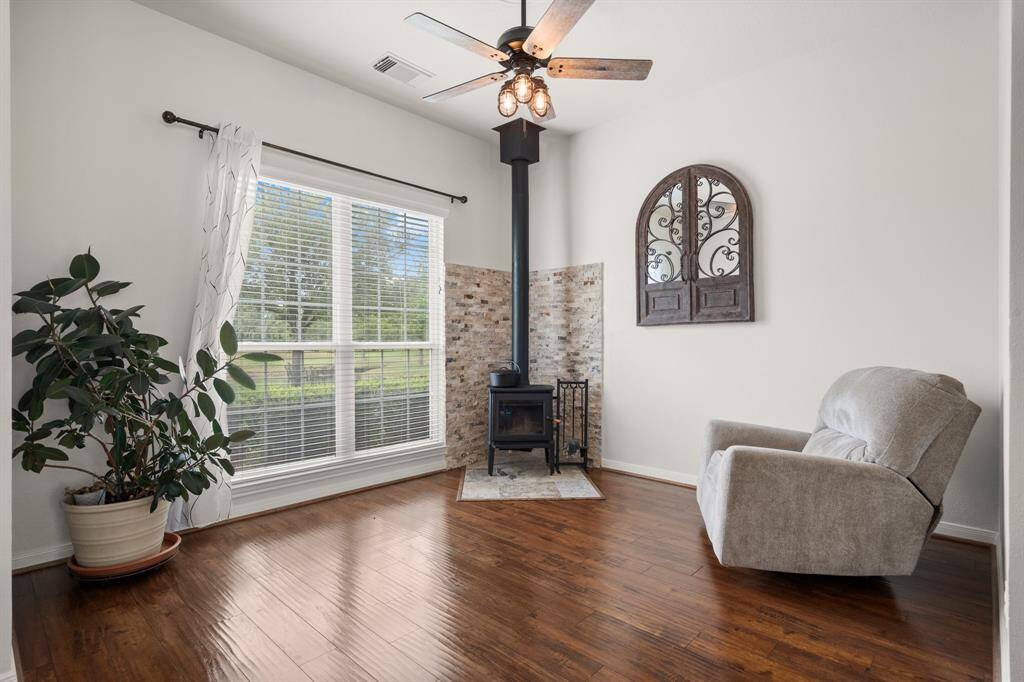 Cozy living area with a charming wood-burning stove, hardwood floors, and ample natural light.