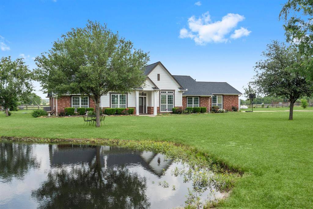 Charming home with a serene pond and expansive lawn, offering a peaceful and picturesque setting.