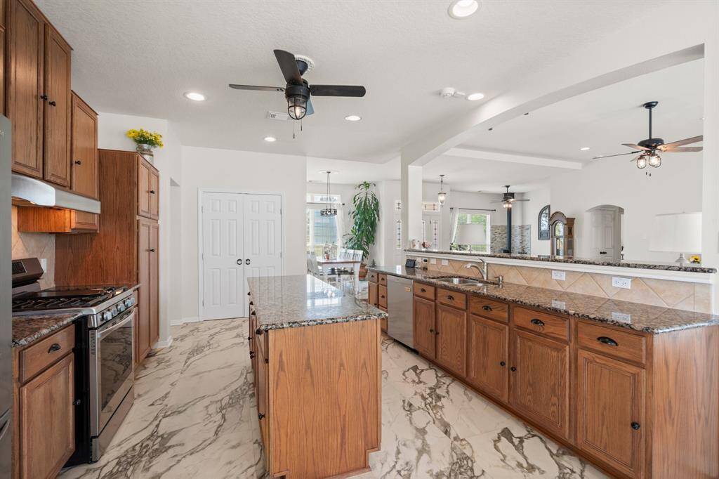 Enjoy the open feel of this spacious kitchen, ideal for entertaining. The large island provides a central gathering point, complemented by ample counter space and stylish wood cabinetry.