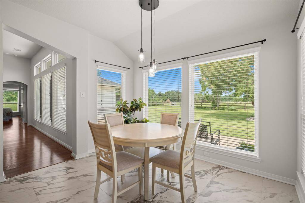 Start your day in this sun-drenched breakfast nook, surrounded by large windows offering expansive views of the outdoors.