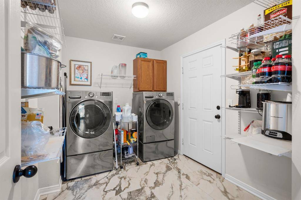 Enjoy the convenience of this dedicated laundry room, complete with space for a washer and dryer and shelving to keep essentials organized.