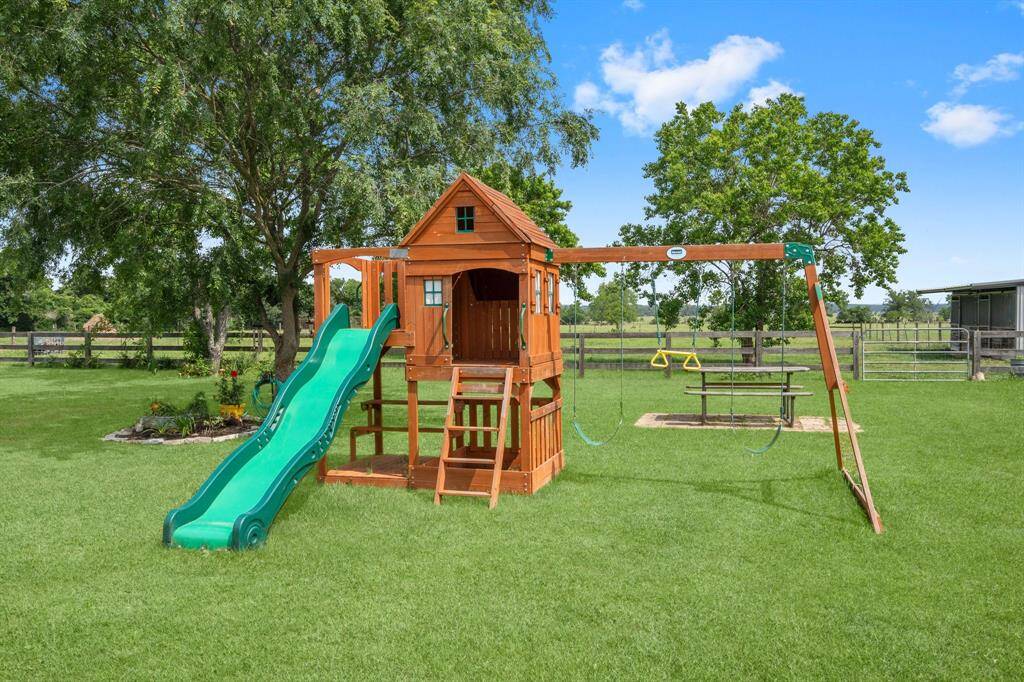 Family-friendly backyard featuring a fun playset with a slide and swings.