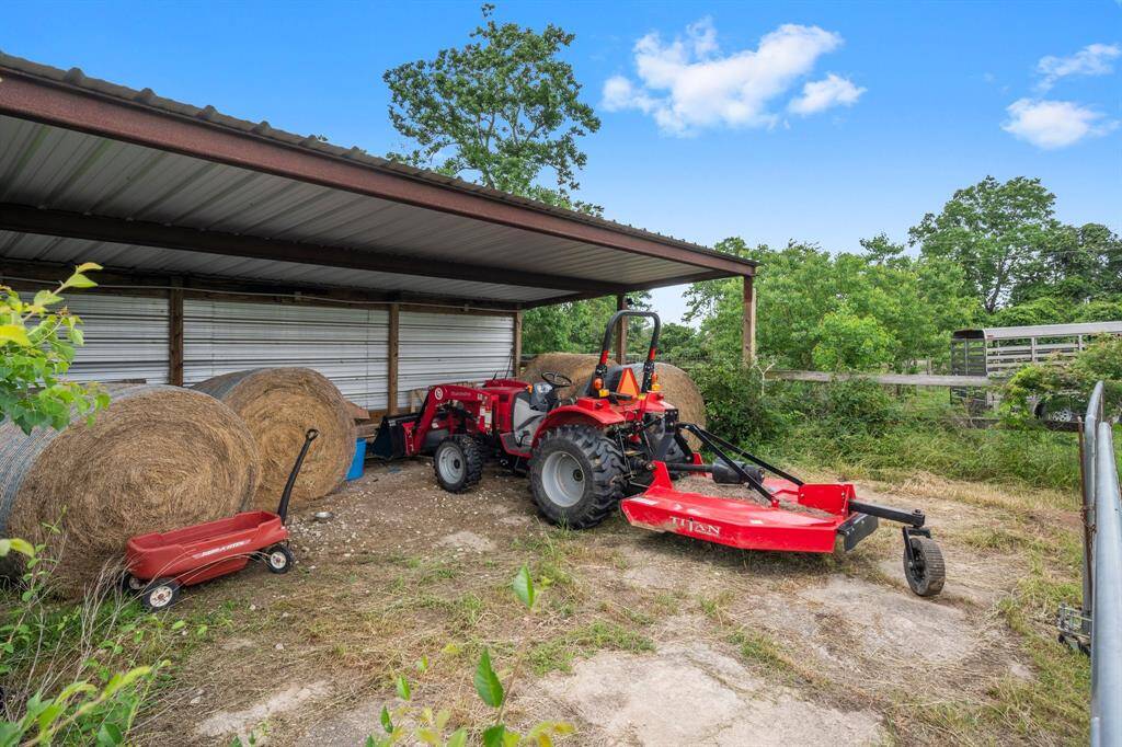 Property includes a tractor and mower under a shelter for easy land maintenance.
