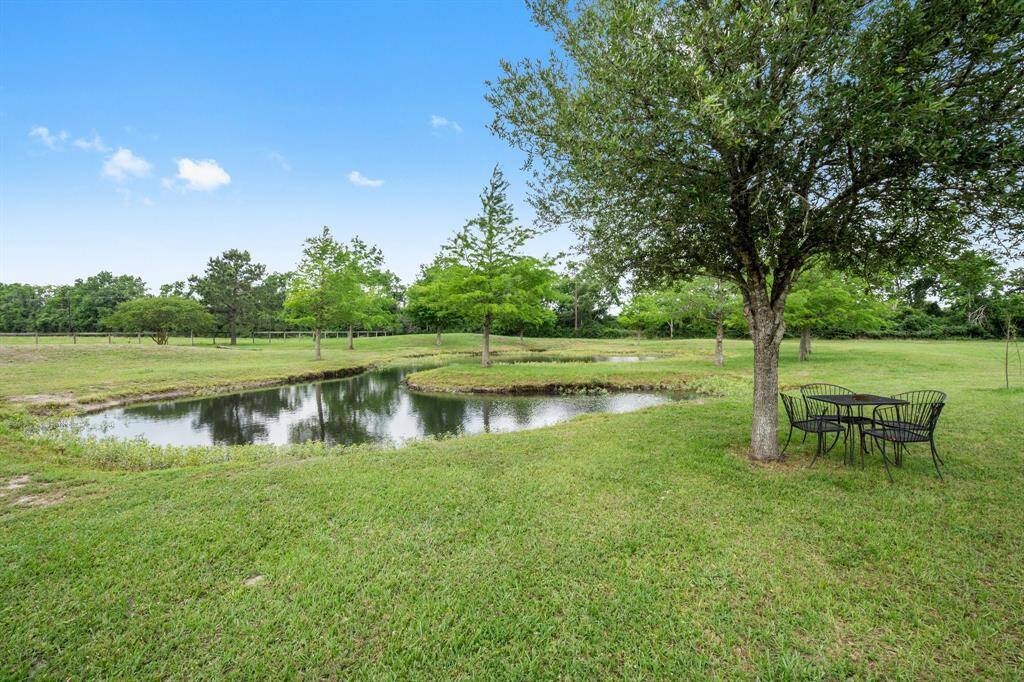 Relax and unwind in this beautiful backyard featuring a tranquil pond and a charming seating area. It's the perfect spot to enjoy the natural beauty of your surroundings.