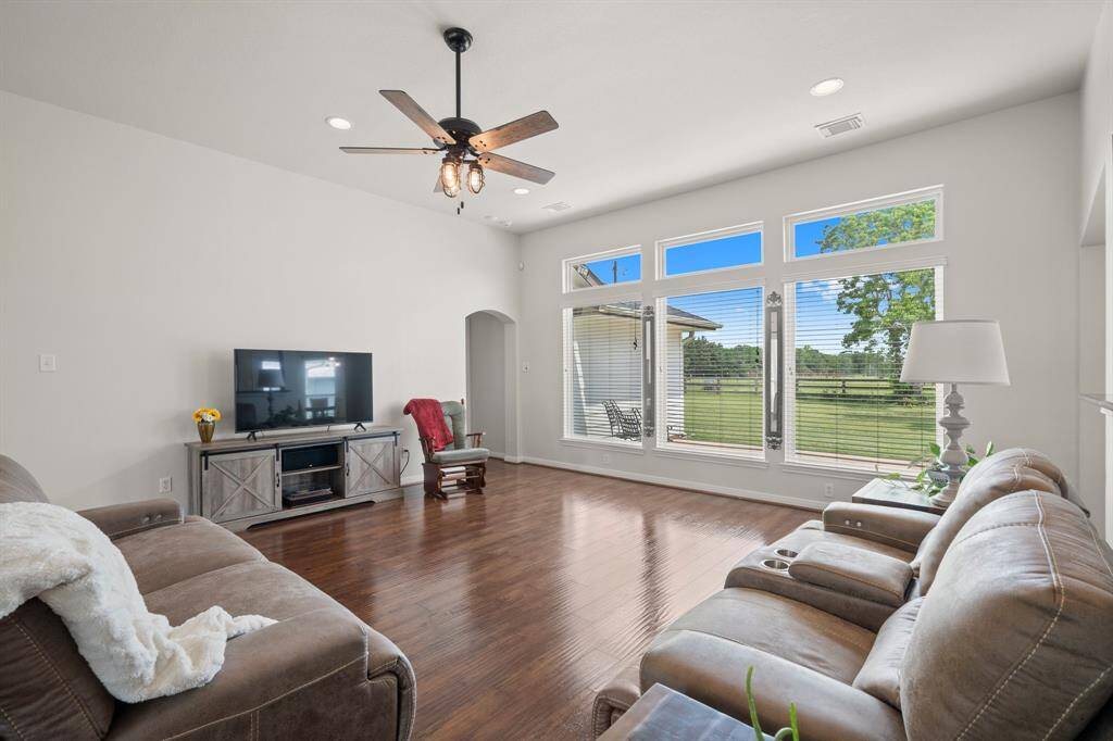 Enjoy the bright and airy atmosphere of this spacious living room, featuring large windows that flood the area with natural light and offer views of the surrounding landscape. It's the perfect space for relaxation and comfortable living.