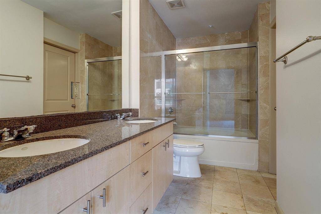 The bathroom contains double sinks, shower/tub combo and a large amount of counter space.