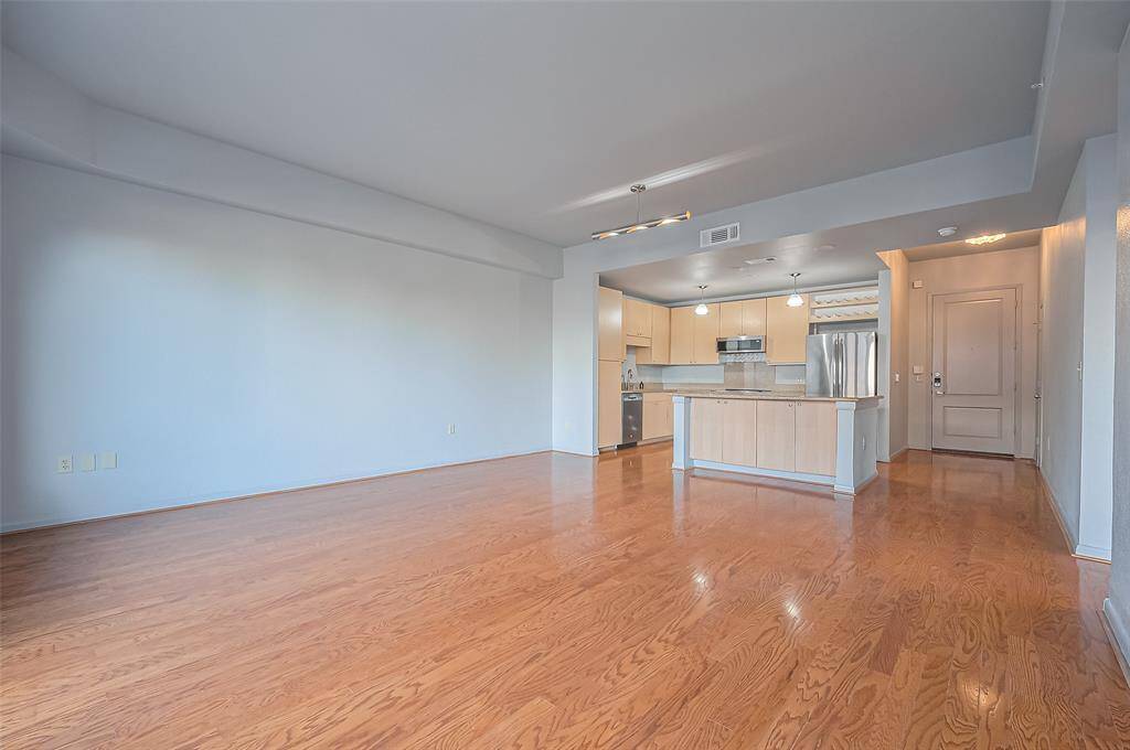 Spacious open-concept living area with hardwood floors, modern kitchen featuring stainless steel appliances, and ample natural light. Perfect for entertaining and comfortable living.