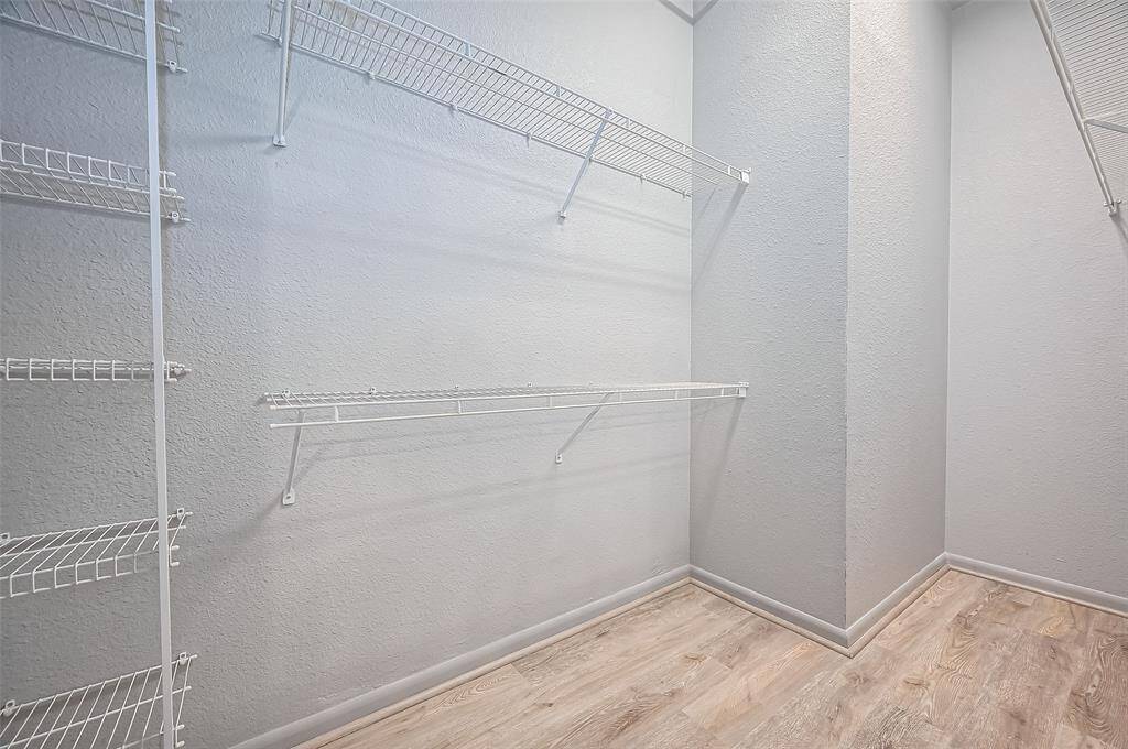 Spacious walk-in closet. It features multiple white wire shelves for ample storage.