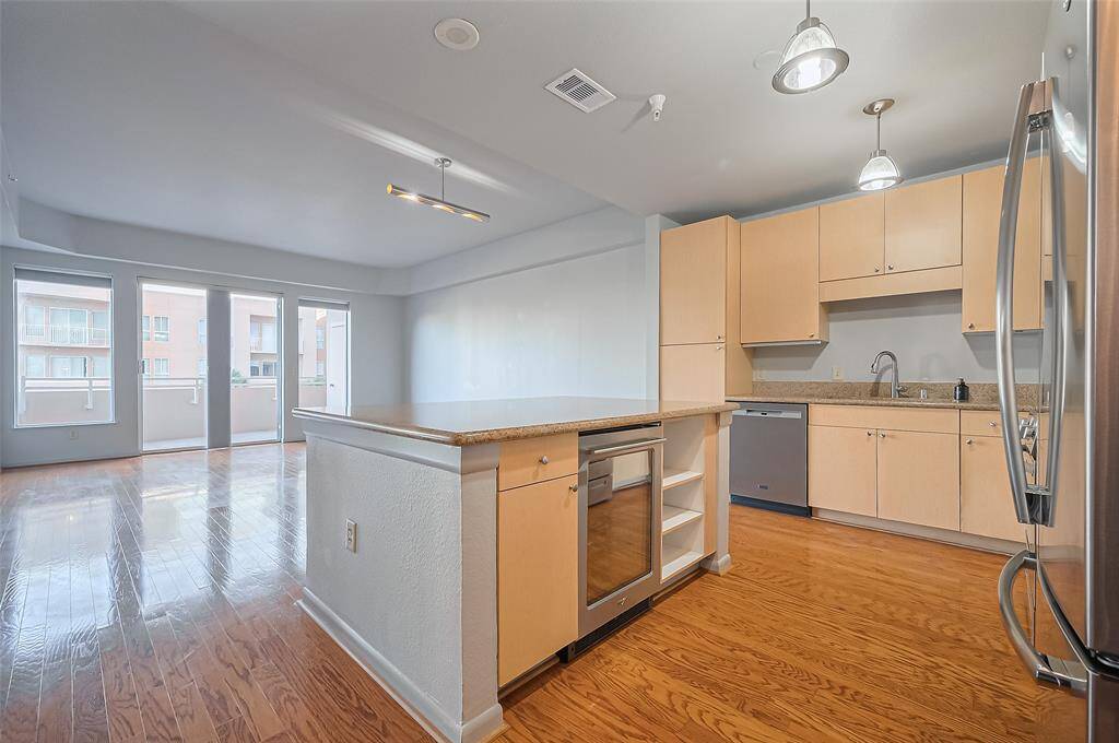 Spacious open-concept living area with hardwood floors, modern kitchen featuring stainless steel appliances, and ample natural light. Perfect for entertaining.