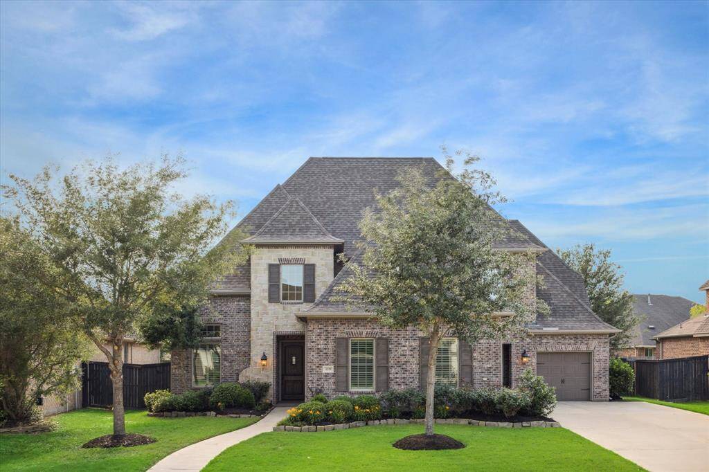 Stunning brick & stone front elevation on this 5 bed/5bath home with 2 primary bedrooms, pool, spa, and outdoor kitchen