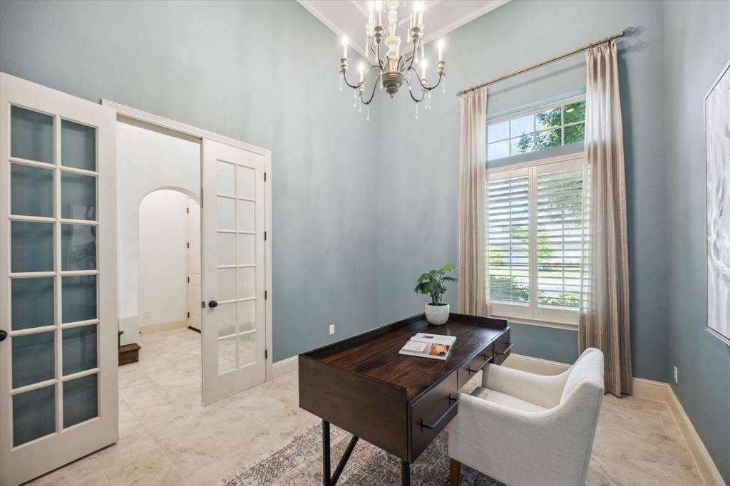 Private office with glass French doors, tall ceilings, plantation shutters, custom window treatments and chandelier