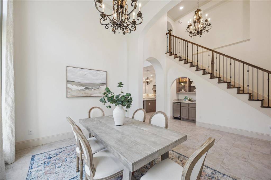 Tons of natural light in this formal dining room  fit for a king with custom window features, chandelier, tall ceilings and plenty of space to host your large gatherings