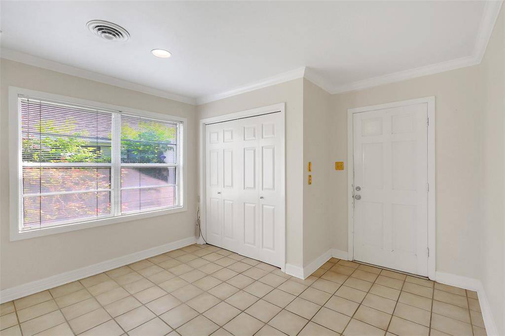 A close up of the breakfast area, utilities closet, and back door to the home.  Just to the right of this shot is a walkway into the den/family area.