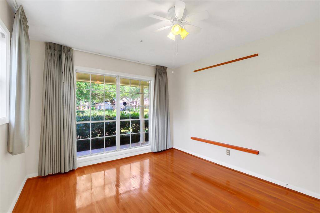 The front bedroom with windows on two sides for nice natural light.  The front window views out to the front yard and street.  This is a nicely sized room and, as all of them do, has the lovely original hardwoods in nice condition.
