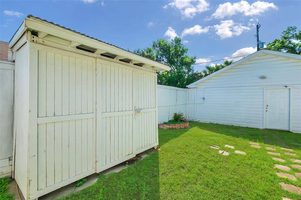 The former garage, as seen at the rear of this photo, was converted years ago into a storage area for art.  It also has a full bath and a separate room which could house a kitchen if desired.  Once all the shelving units would be removed, it would be an excellent candidate for a separate apartment, perfect for family member, live-in help, or student.  Of course, it likely could be returned to a two car garage also.  The building in the foreground is just additional storage also.