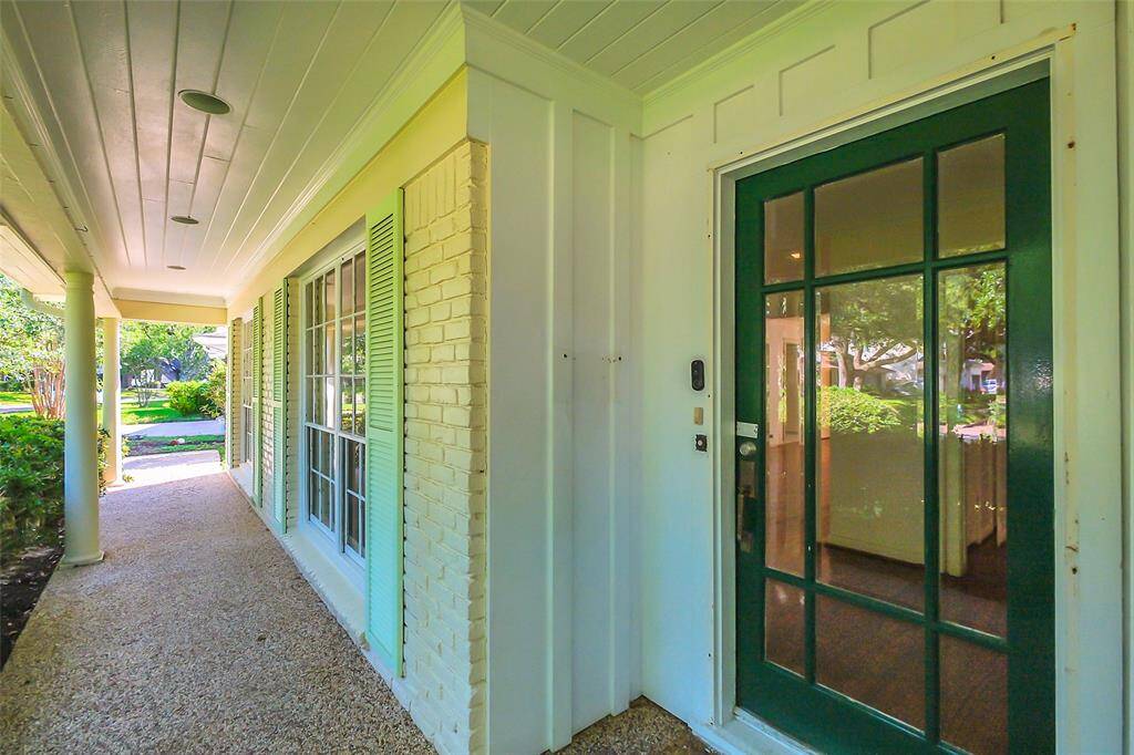 From the driveway, the pebbled front porch walkway has recessed lighting above and comes to the very pretty glass paneled front door.