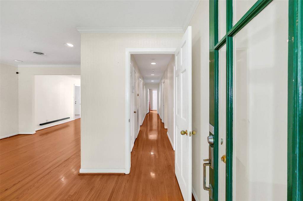 Upon entering, there is a foyer which then opens either down the bedroom side corridor, which may be closed, or into the living areas of the home. Note the still shimmering original hardwood flooring which extends throughout the majority of the home.