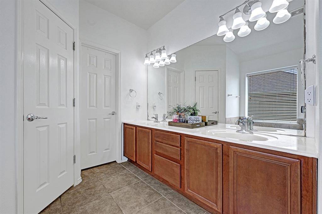 The primary bath features a double vanity with both cabinet storage and nice counter space, as well as a large closet with built-in storage.