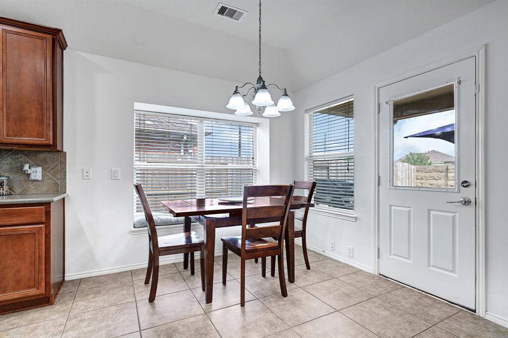 The breakfast table area features a cozy window seat and is light and bright.