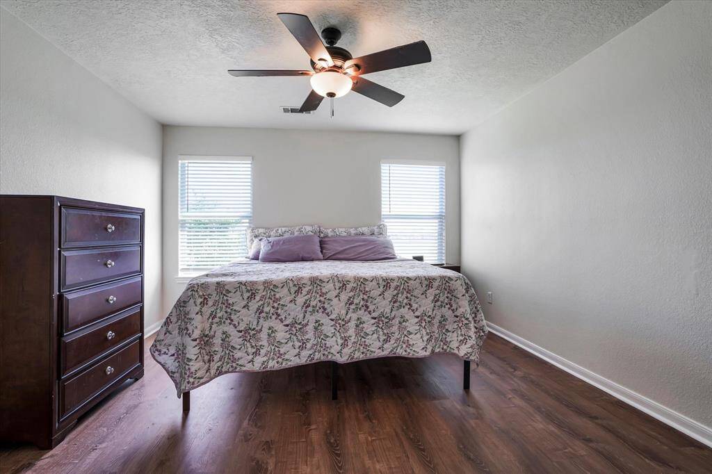 Generously sized primary suite with large windows and peaceful backyard views.