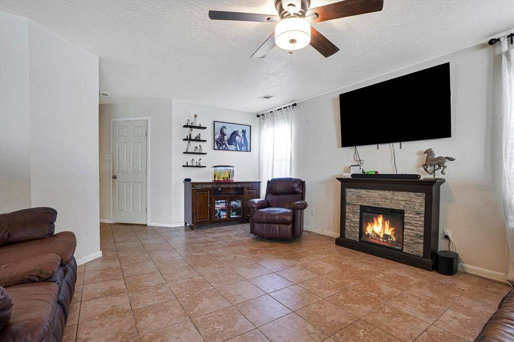 Spacious and bright living area featuring an inviting fireplace, perfect for cozy nights and entertaining guests