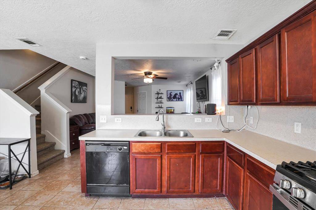 Functional kitchen with ample cabinet space, updated appliances, and a breakfast bar that opens to the living room for easy entertaining