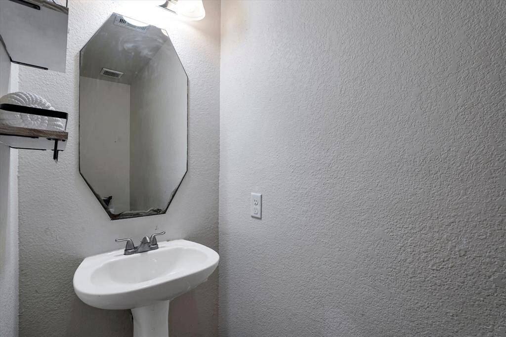 Conveniently located downstairs with a pedestal sink and toilet, perfect for guests.