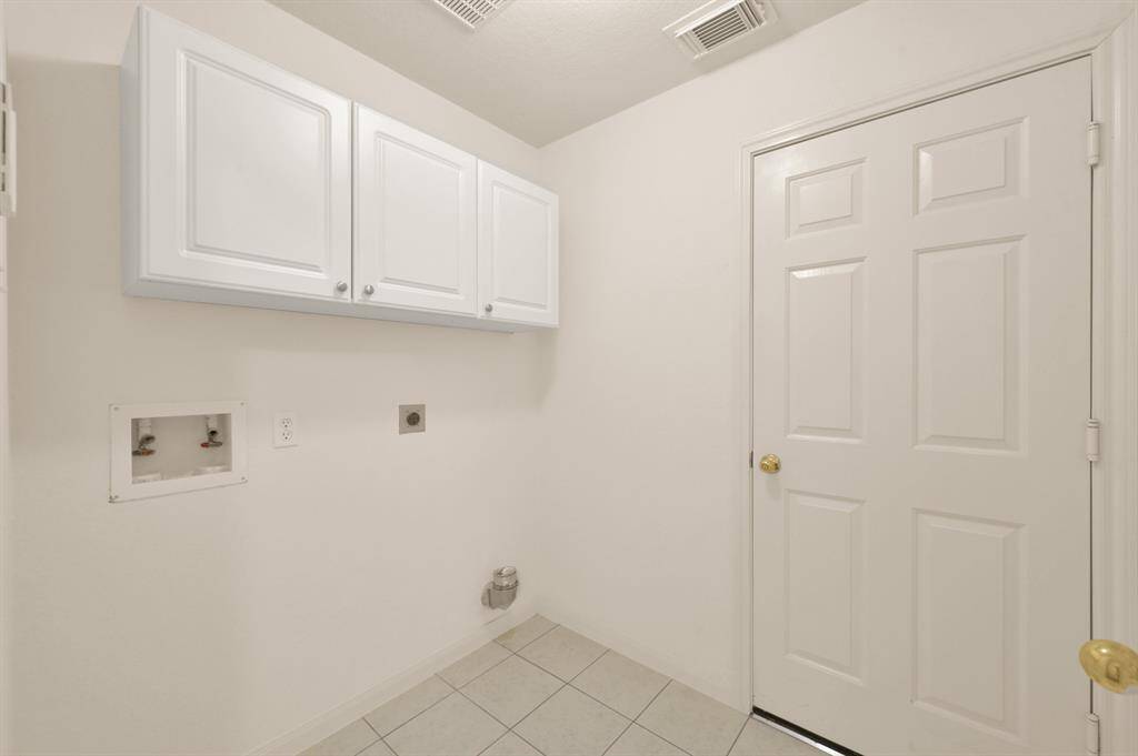 Laundry room with built in cabinets. New ceramic tile May 2025.