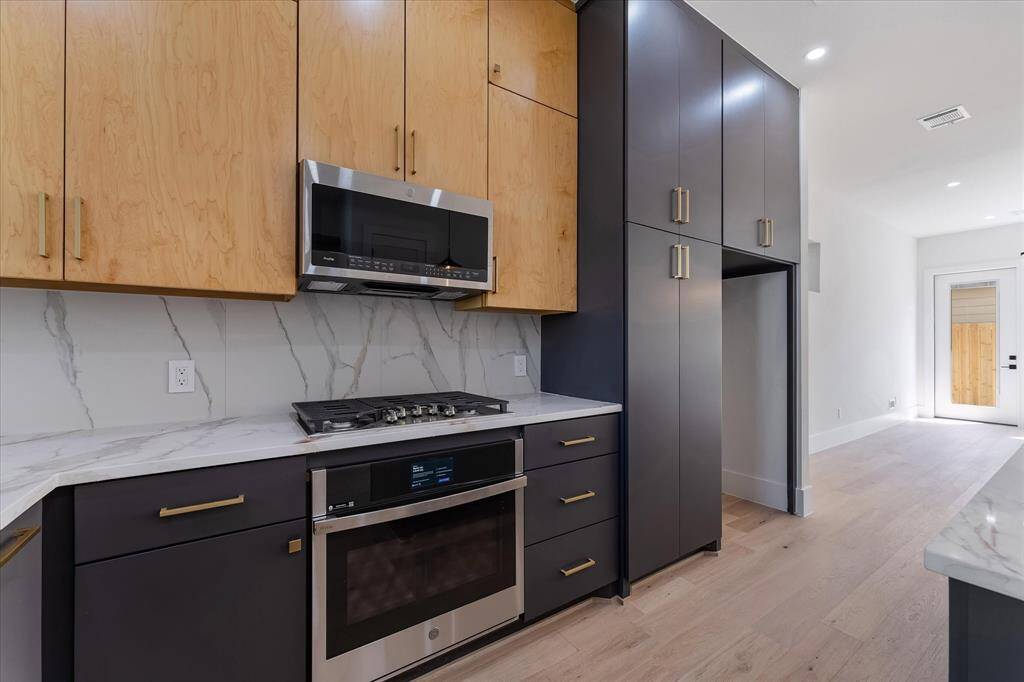 Kitchen: Custom Cabinetry and large format tile to the ceiling. Expansive island and GE Profile Appliances (Fridge not included)