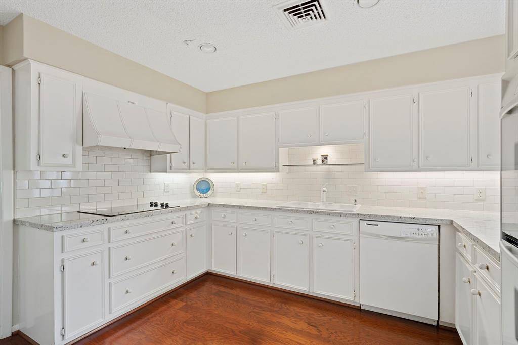 The bright and cheerful kitchen is a true standout with updated light granite countertops, classic white subway tile backsplash, glass cooktop, pot & pan drawers, pantry, under-cabinet lighting.